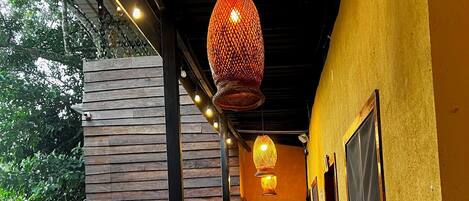 Un pasillo con pared de madera, luces colgantes y plantas en macetas.
