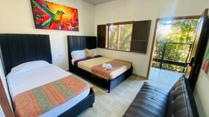 Habitación de hotel con dos camas, un balcón y un ventanal grande.