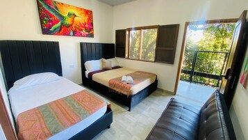 Habitación de hotel con dos camas, un balcón y un ventanal grande.