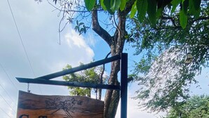 Un letrero de madera que dice 'Coffee House Minca' colgado de un poste de metal.
