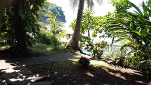 A garden pathway leading to a pool area with tropical plants and a view of the ocean. - El Patio de Don Moncho - Shalpa (Jicalapa)