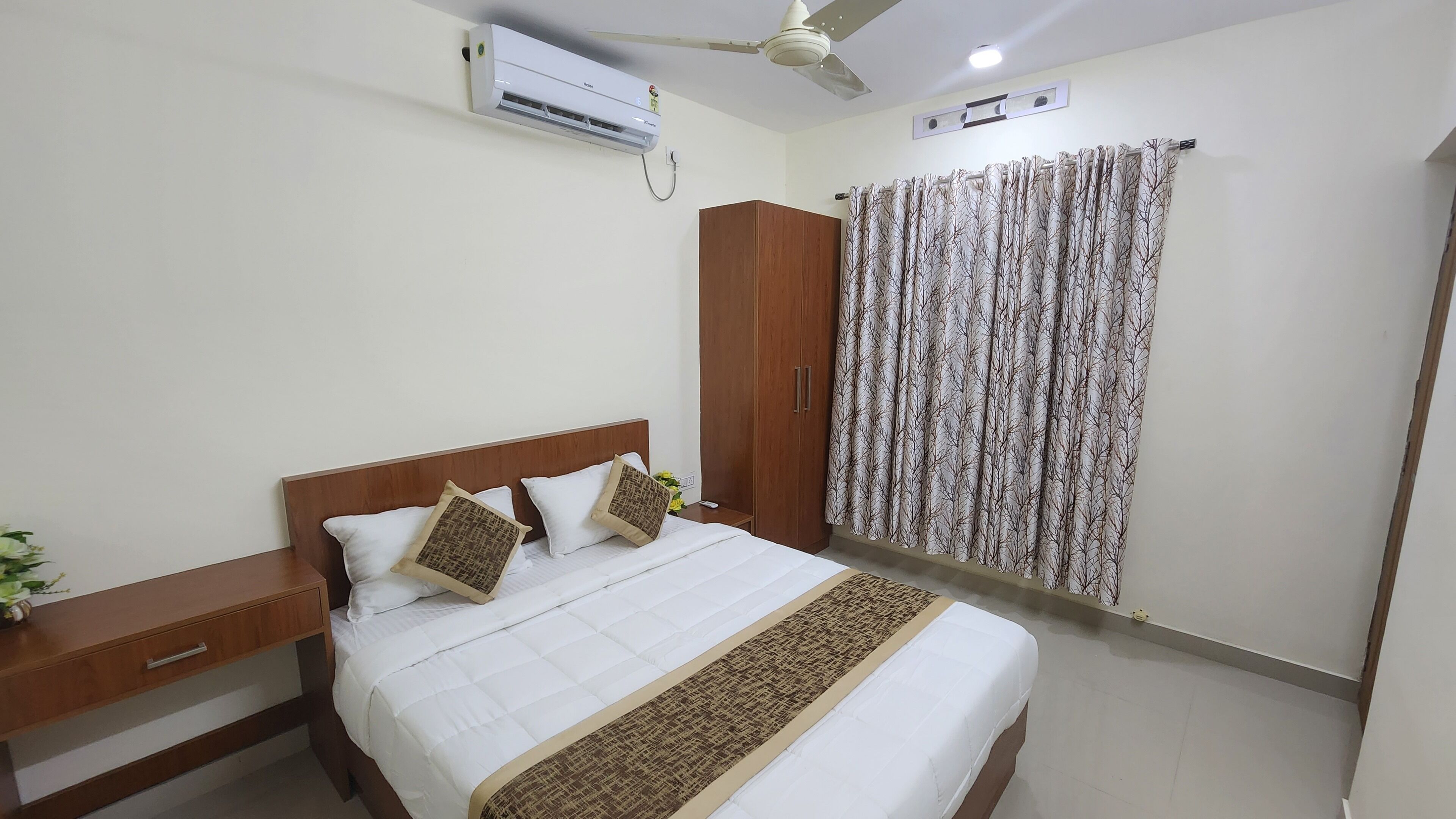 Une chambre d’hôtel avec un lit, une armoire en bois et un appareil de climatisation.
