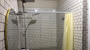 A shower with a yellow curtain, a handheld showerhead, and a wall-mounted faucet. - Serene one bedroom apartment in a quiet residential area, privacy assured  (Accra)