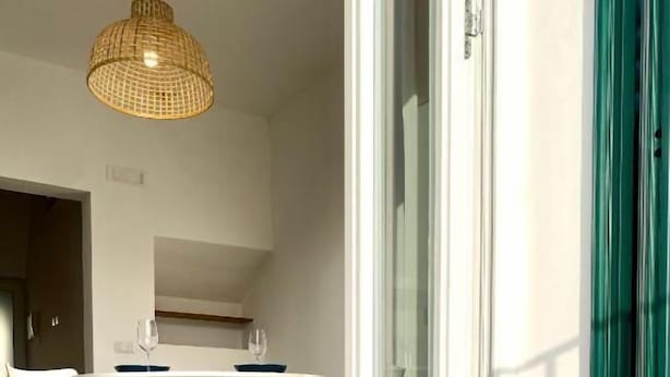 Un coin repas avec une table ronde, quatre chaises et un luminaire suspendu.