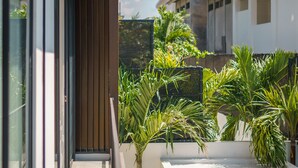 A modern building with a narrow balcony, potted plants, and a clear sky. - Villa Vantage 7 (Kerobokan)