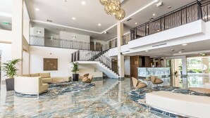 A spacious lobby with a marble floor, a staircase, and a reception desk. - Hope Harbour Hotel Apartments (Hope Island)