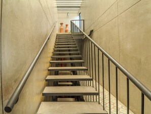 Staircase with a minimalist design, featuring a metal handrail and steps leading upwards.
