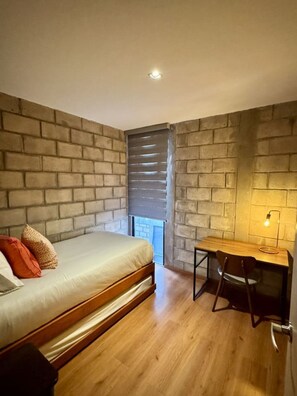 A bedroom with a bed, a desk, and a chair. There is a window with blinds. - Double Deluxe Apartment with Terrace - 406 (Guadalajara)