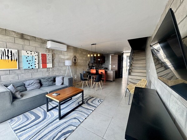 A modern living room with a sofa, coffee table, and artwork on the wall.