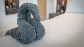 A bed with a grey knitted swan-shaped pillow. - OYO Bellevue Apartments Middlesborough (Middlesbrough)