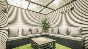 A modern, enclosed patio area with a built-in bench and a small table. - OYO Bellevue Apartments Middlesborough (Middlesbrough)