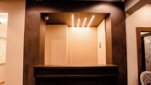 A modern elevator with a wooden finish and a security camera. - Hotel Jsr Ganga (Varanasi)