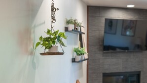Un comedor moderno con una mesa de madera, individuales tejidos y taburetes de bar.