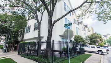 Stroll through the charming residential area, featuring a two-story building with a balcony and a beautifully manicured garden.