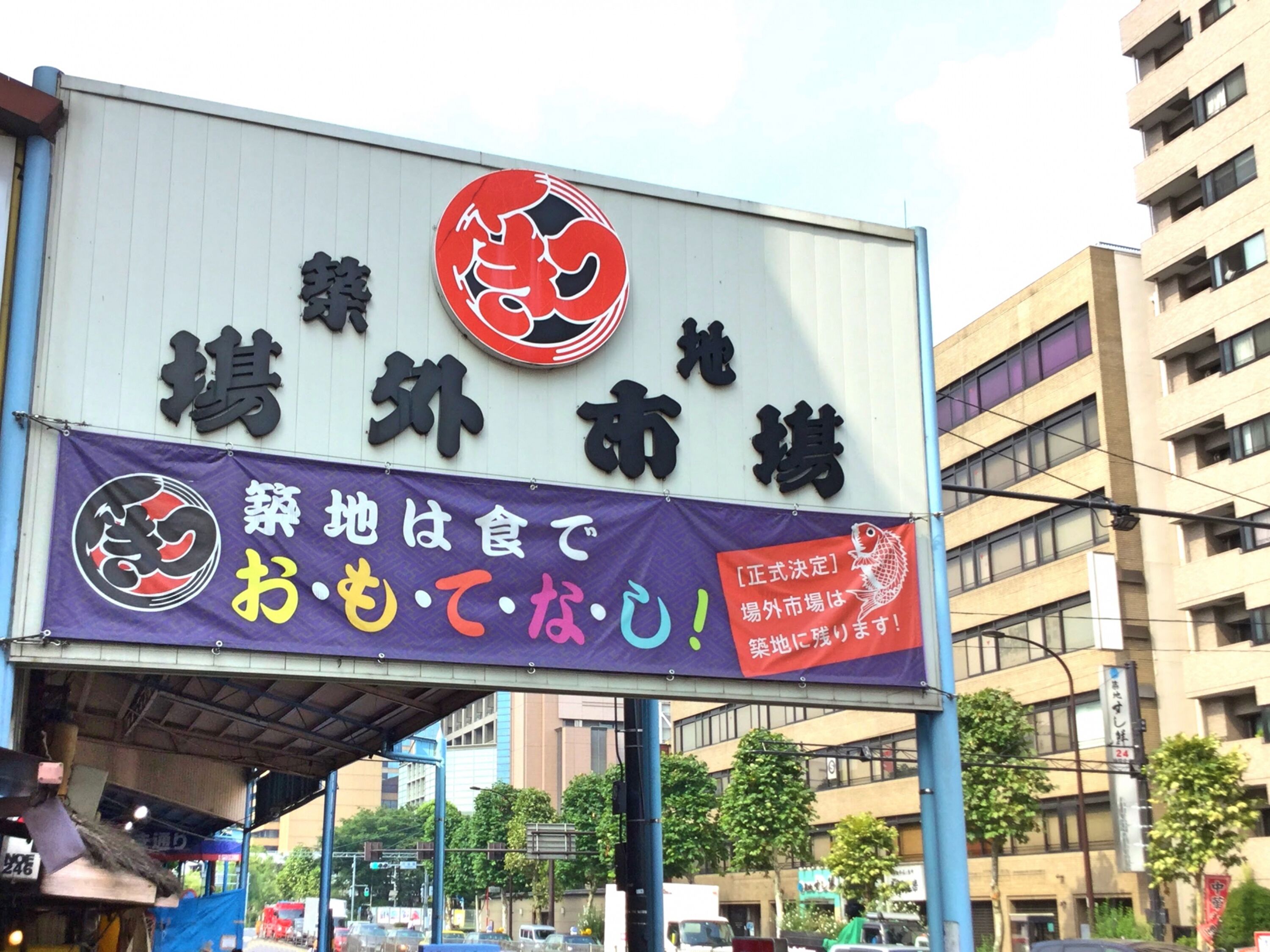 A signboard with Japanese text and a red emblem, likely advertising a local business or service.