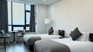 A modern hotel room with two beds, a desk, and a chair. - JD Tower Hotel (Seoul)