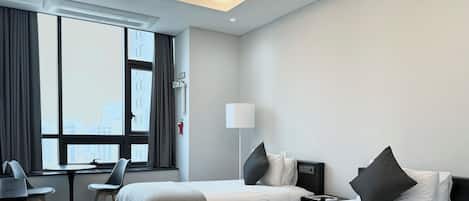 Una habitación de hotel moderna con dos camas, un escritorio y una silla.