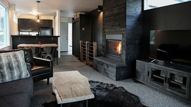 A modern living room with a fireplace, a dining area, and a kitchen. - 16 Village Run... 2 Bedroom Condo by RedAwning (Warren)