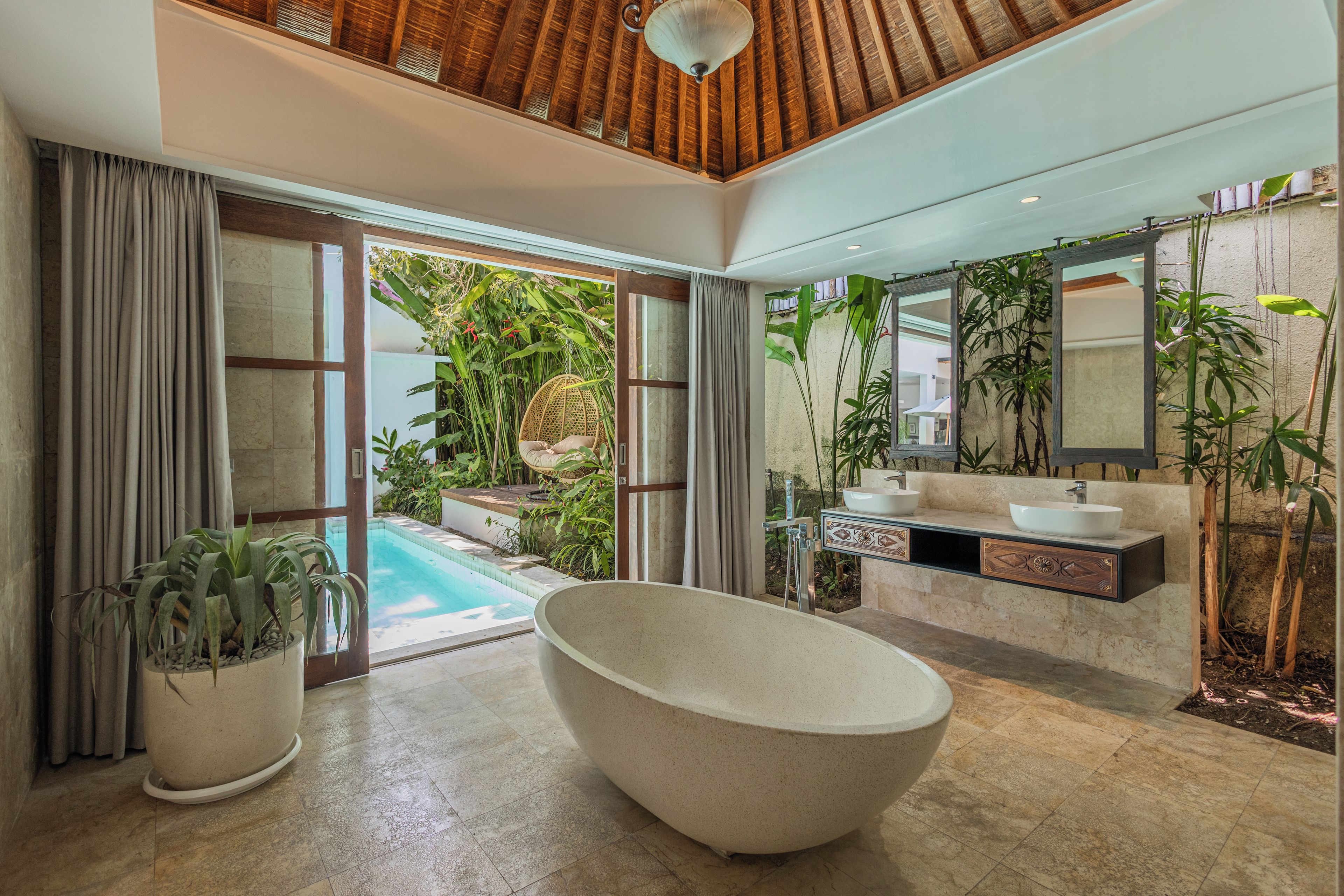 Une salle de bain moderne avec une baignoire sur pieds, un grand miroir et un lavabo agrémenté d’un meuble décoratif.