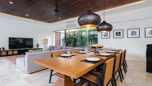 Een moderne eetruimte met een houten tafel, stoelen en hanglampen.