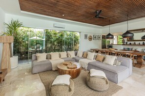Ein modernes Wohnzimmer mit einem Ecksofa, einem Holztisch und einem Essbereich mit einem Holztisch und Stühlen.
