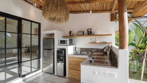 Een moderne keuken met een groot eiland, inbouwapparatuur en een hangende lamp.