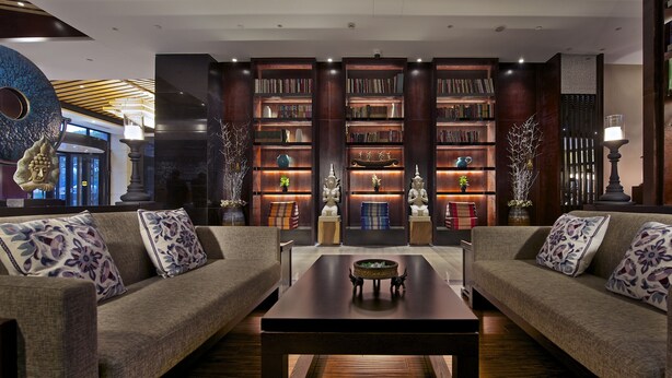 A modern living room with two sofas, a coffee table, and a bookshelf filled with books. - SSAW Boutique Hotel Shanghai Hongkou (Shanghai)