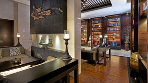 A modern lobby with a sofa, a coffee table, a fireplace, and a bookshelf filled with books. - SSAW Boutique Hotel Shanghai Hongkou (Shanghai)