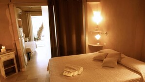Een hotelkamer met een groot bed, een nachtkastje met lamp en uitzicht.