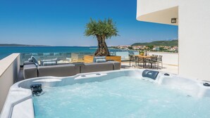 A rooftop terrace with a hot tub, seating area, and a view of the sea. - Villa Four Seasons Ljubac (Razanac)