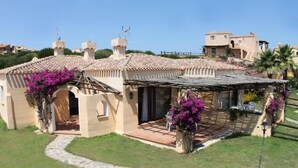 A Mediterranean-style villa with a tiled roof, a covered patio, and a stone pathway leading to the entrance. - Charming Sea Villas Es Sleeps 6 With Private Pool Extra bed Possible (Stintino)
