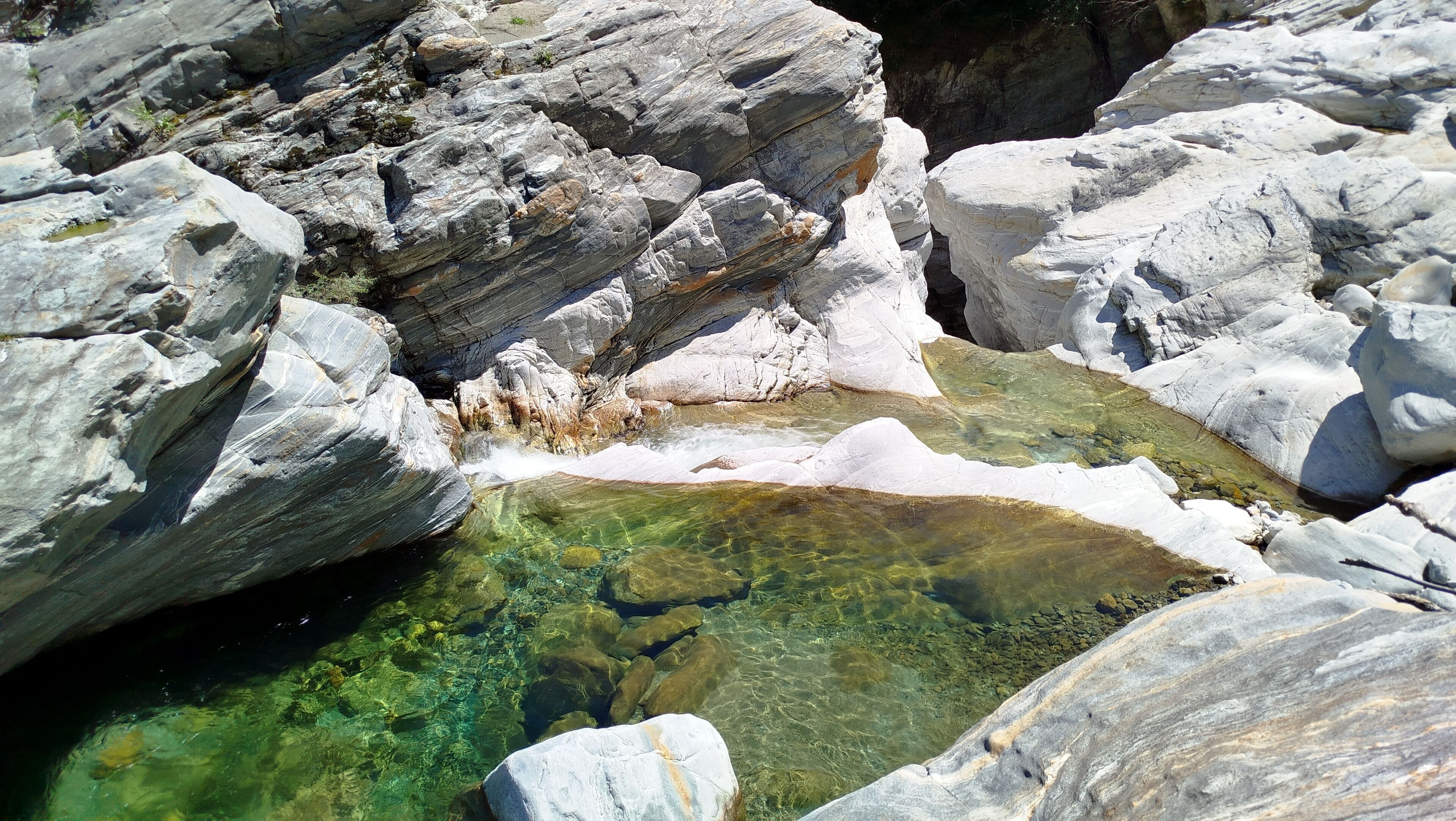 A rocky landscape with clear water pools and large boulders.