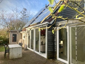 A house with a covered patio, a small shed, and a solar panel array. - Holiday Home - 5 Persons - Closet to the Lauwerslake Near Wadden Sea (Anjum)