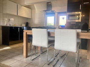 A modern kitchen with a central island, stainless steel appliances, and a window providing natural light.