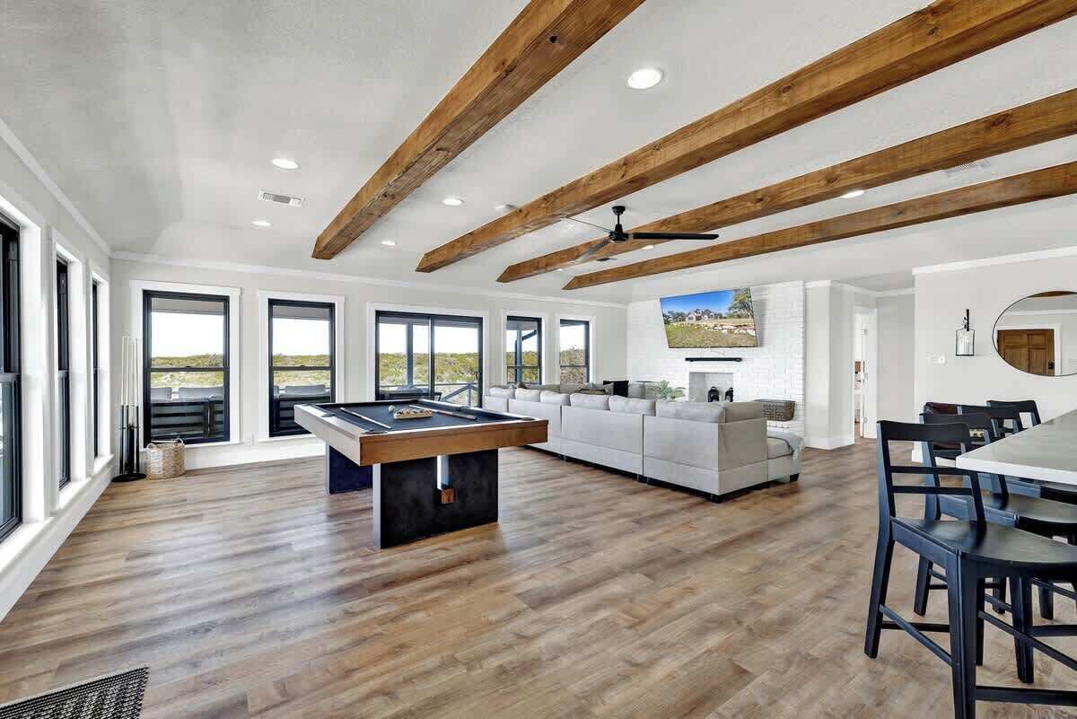 A spacious living area with a pool table, a sofa, and a dining table.