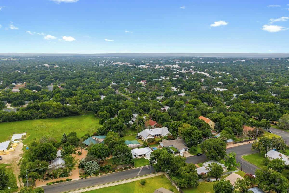 Vue aérienne d’un quartier résidentiel avec des maisons, des rues et des espaces verts.