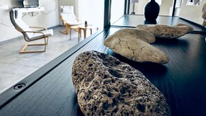 Quarto moderno com mesa de madeira escura, televisão, cadeira e um vaso.