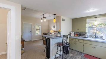 A kitchen with a central island, a sink, and a window.