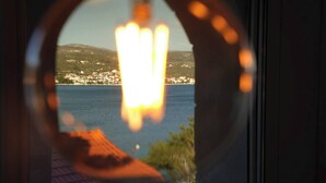A window view of a coastal town with houses and a body of water. - Villa Captains House 2 (Rogoznica)