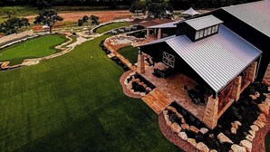 Un campo de golf con un club de campo y una vista panorámica al atardecer.