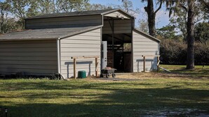 A single-story building with a gabled roof, a large open doorway, and a small porch area.