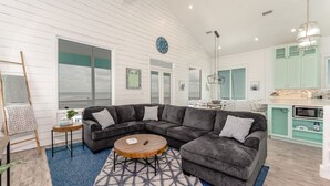 A modern living room with a sectional sofa, a round coffee table, and a blue patterned rug.
