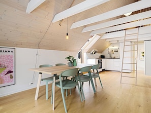 A modern kitchen with a lofted dining area, wooden beams, and a ladder. - Charming Rooftop Apartment In Heart Of Stavanger (Stavanger)