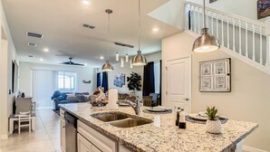 A spacious kitchen with granite countertops, stainless steel sinks, pendant lighting, and a view to the living area. - Windsor Island 7br, Free Pool Heat, 5min Walk To L (Davenport)