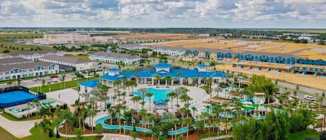 A resort with multiple buildings, a central pool area, and surrounding greenery.