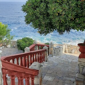 Una escalera de piedra que conduce a un balcón con vistas al mar.