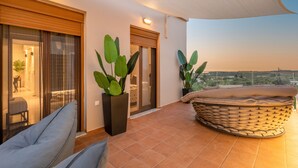 A balcony with a cushioned seating area, large potted plants, and a view of the landscape. - Villa Ismini 3 Bedrooms With Pool , sea View and E-car Charger (Rethymno)
