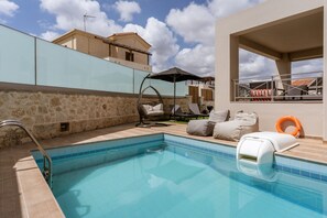 Ein Pool mit Glaswand, Hängesessel und Rettungsring.