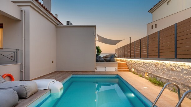 A swimming pool with a sun lounger and a stone wall. - Villa Ismini 3 Bedrooms With Pool , sea View and E-car Charger (Rethymno)