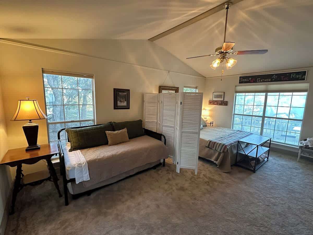 Ein gemütliches Zimmer mit Bett, Schreibtisch, Lampe und Fenster.